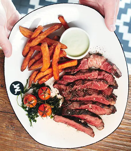 Der Teller ist angerichtet mit einem saftigen Steak und knusprigen Pommes